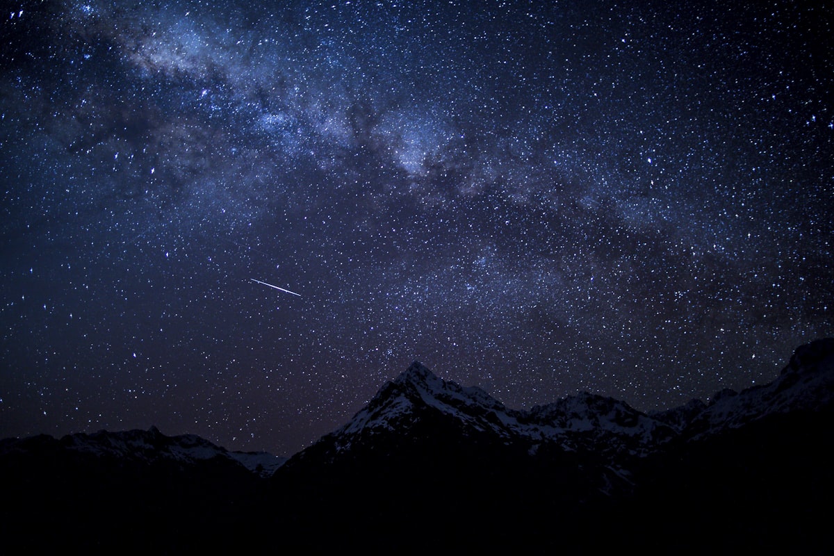 夜空に流れる流れ星と満天の星